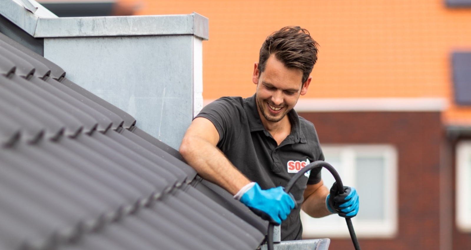 een man maakt zijn dakgoot schoon