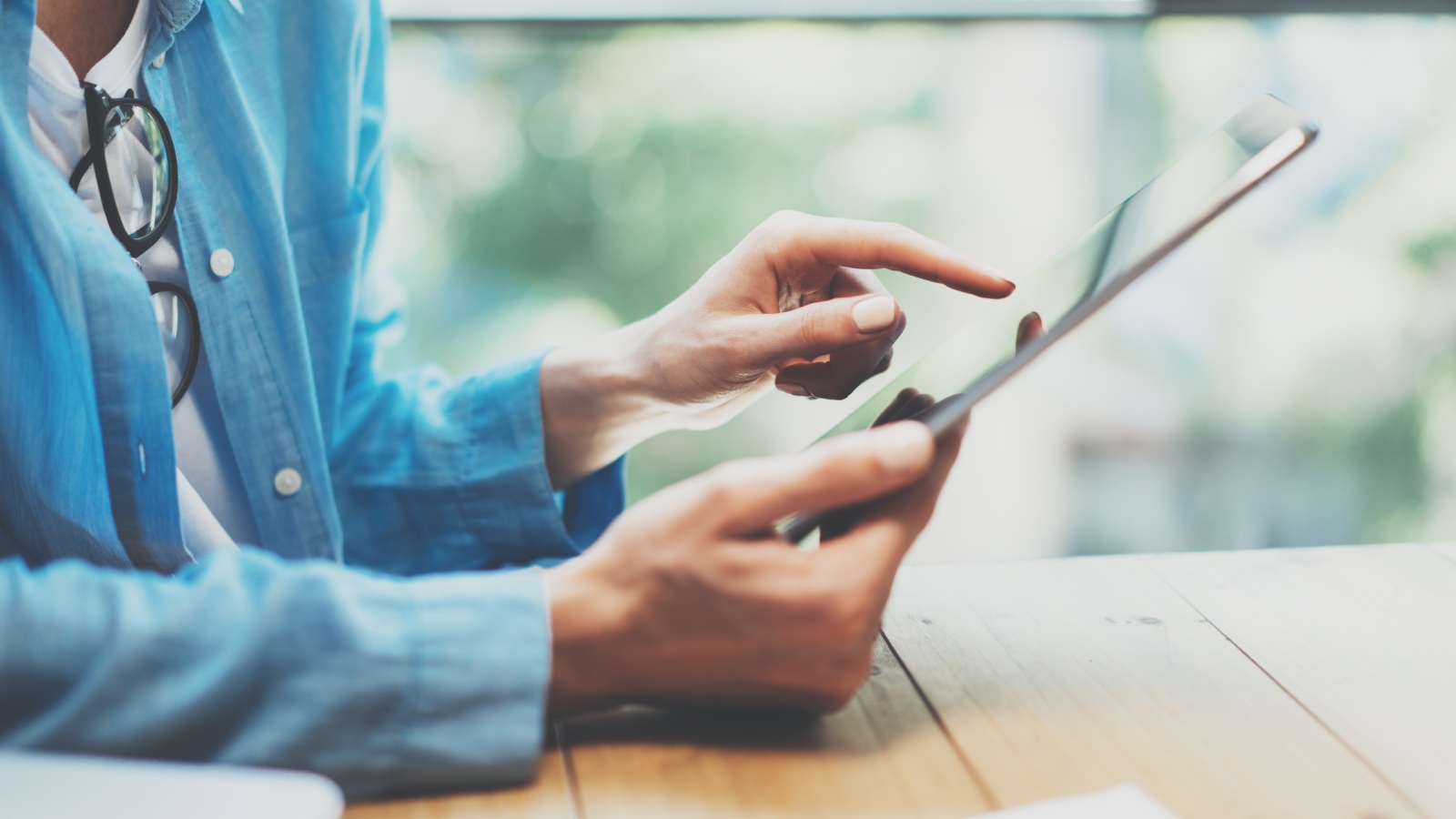 Iemand houdt een tablet vast en tikt op het scherm